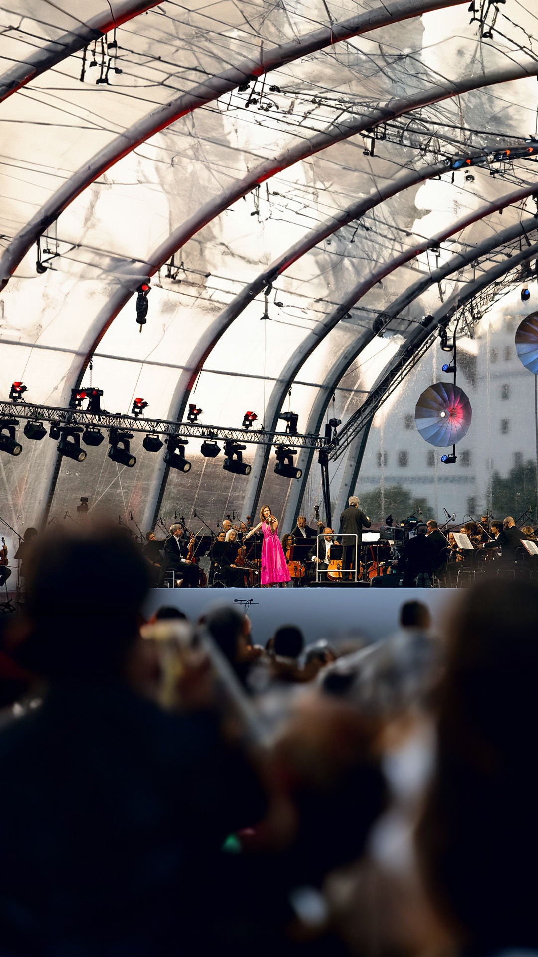 Orchester spielt auf Bühne vor großem Publikum.