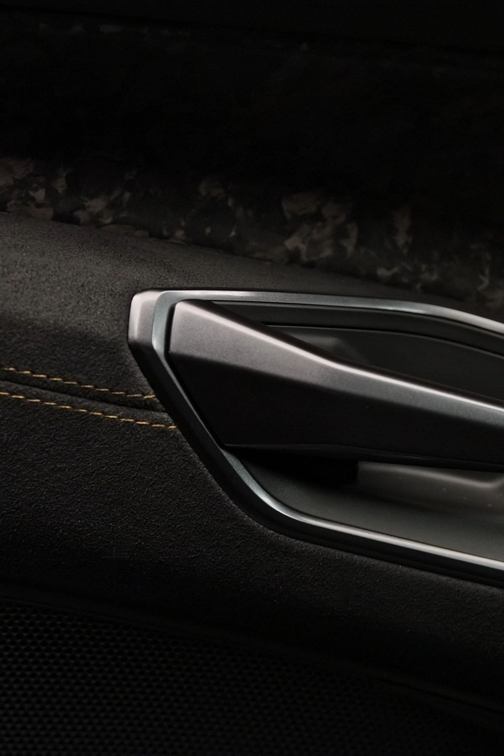L'intérieur de la Nouvelle Audi RS e-tron GT performance¹ est orné de surpiqûres vertes serpentines. Le camouflage en carbone de l'extérieur se retrouve notamment dans les moulures de porte.