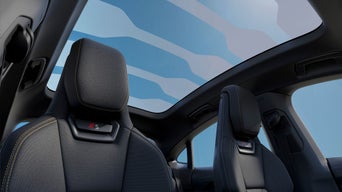 Interior view of a car showing two black seats with a large panoramic sunroof.