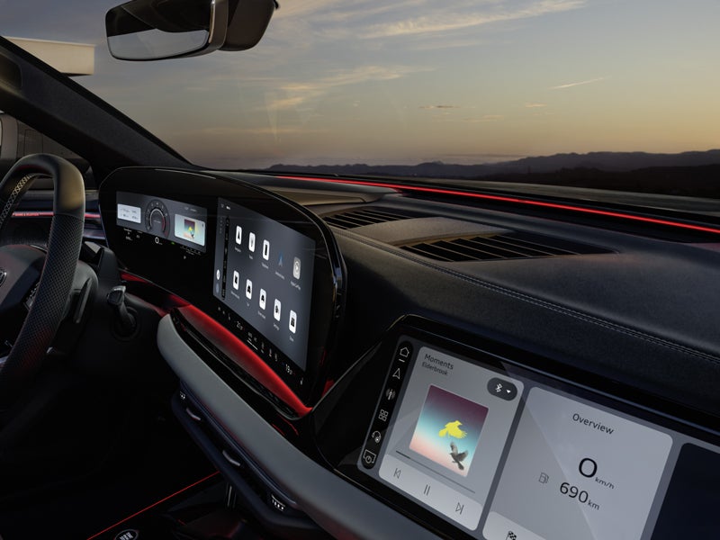 Vy över passagerardisplayen, MMI och ratten från passagerarens perspektiv.