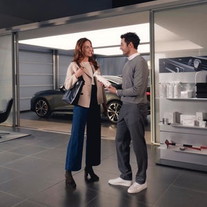 A man and a woman talking inside a car dealership