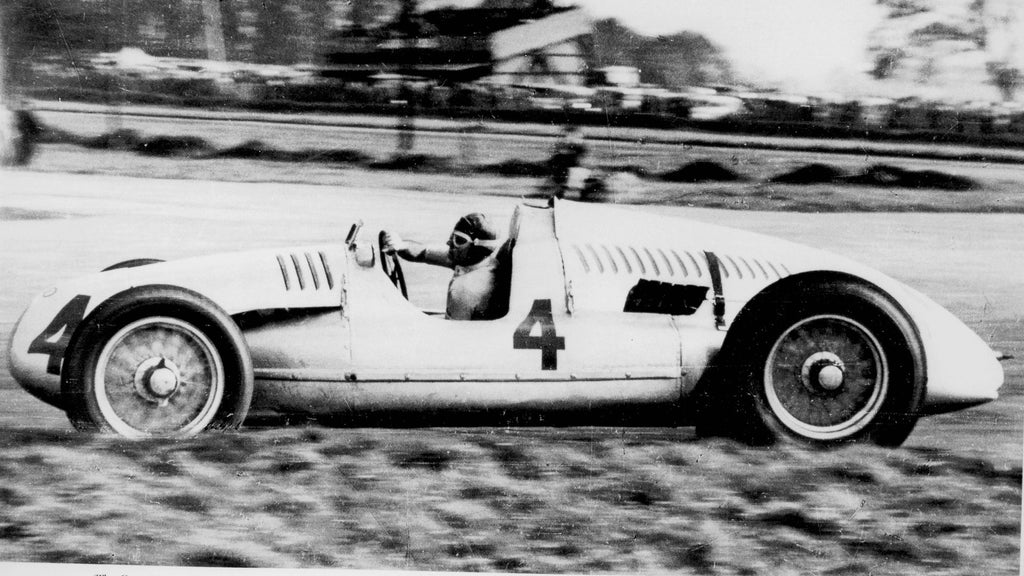 Historic photograph of racing driver Tazio Nuvolari competing in an Auto Union Grand Prix race car.