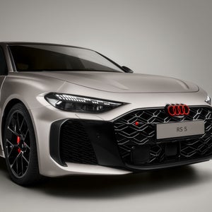 Close-up der Front des Audi RS 5 mit Fokus auf den Lufteinlass. Die lavaroten Audi Ringe an der Fronthaube sind deutlich zu erkennen.