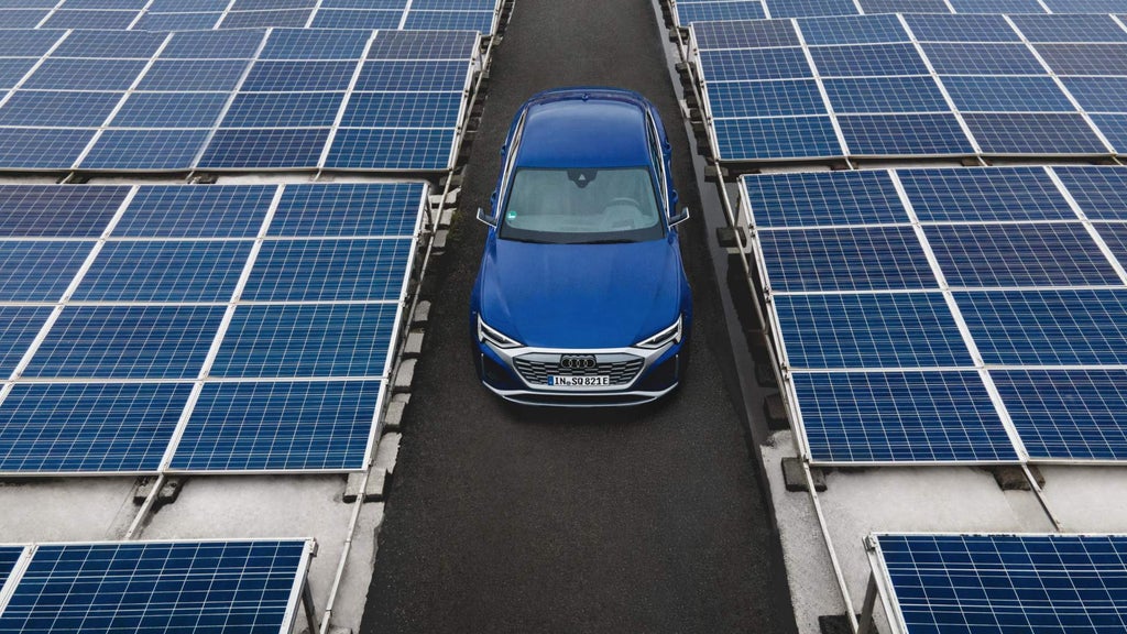 The Audi Q8 e-tron{ft_q8-e-tron} in the middle of the photovoltaic installation.
