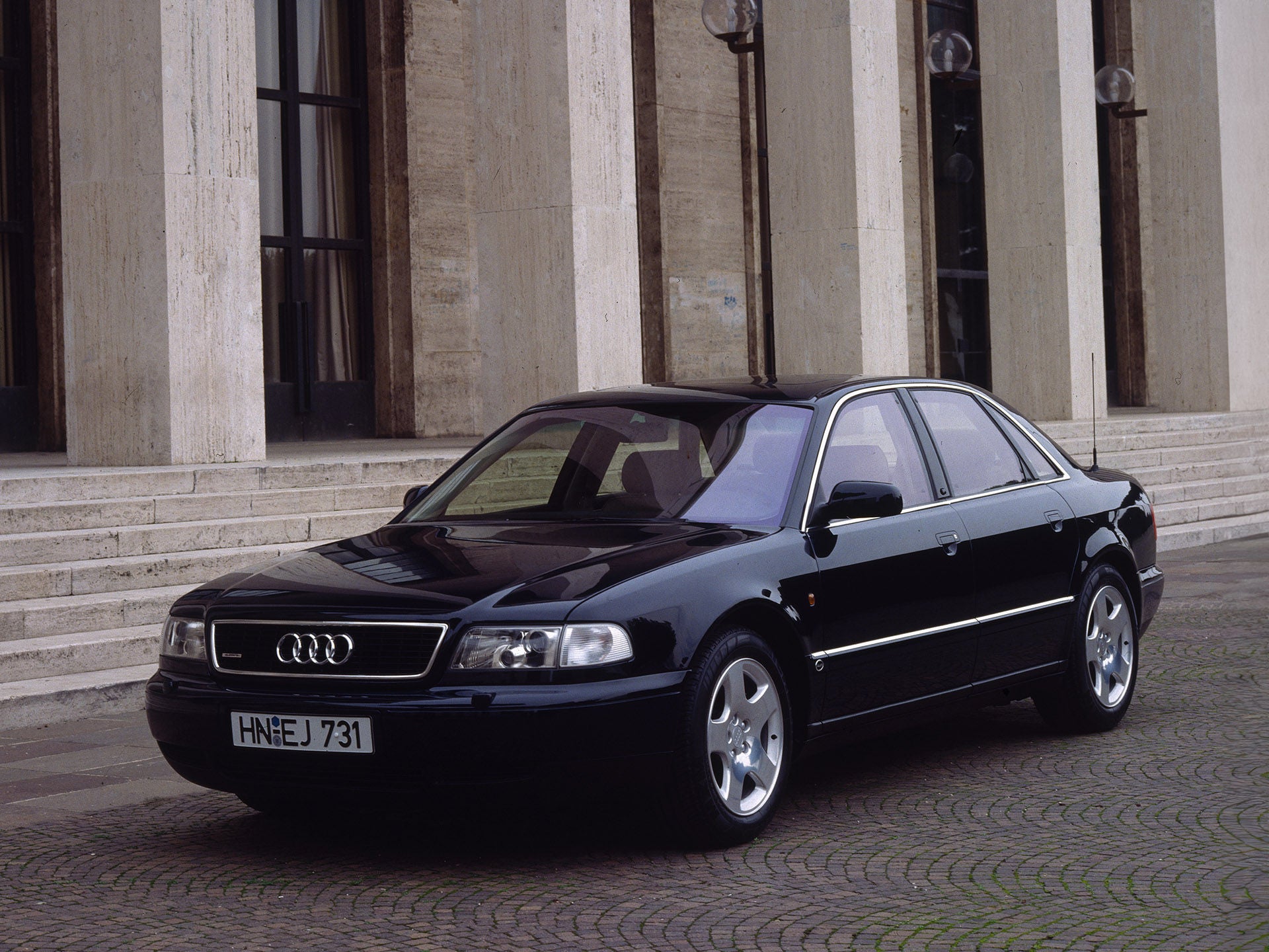 Ein schwarzer Audi A8 4.2 quattro in der Front-Seitenansicht vor einem Gebäude mit Steinsäulen