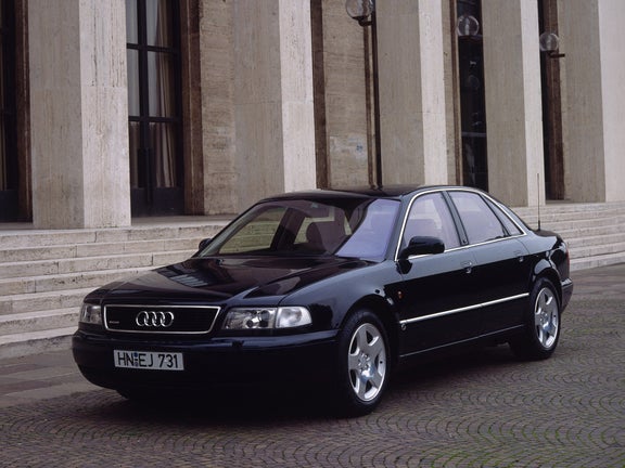 Front side view of a black Audi A8 4.2 quattro in front of a building with stone pillars