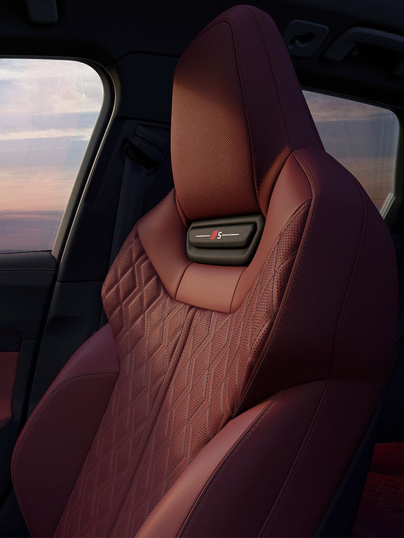 Roter Sportsitz im Audi S5 Avant mit gestepptem Muster und integriertem „S“-Logo in der Kopfstütze.
