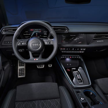 Interior view of an Audi S3 car with steering wheel, digital dashboard, and center console.