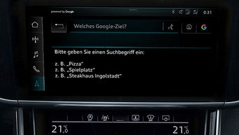 Fahrzeugdisplay mit Google-Zielsuche, Beispielbegriffe wie „Pizza“ oder „Spielplatz“ werden angezeigt.
