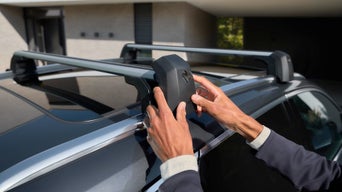 Nahaufnahme eines Audi-Dachträgers bei Sonnenlicht, montiert auf glänzendem Fahrzeugdach.