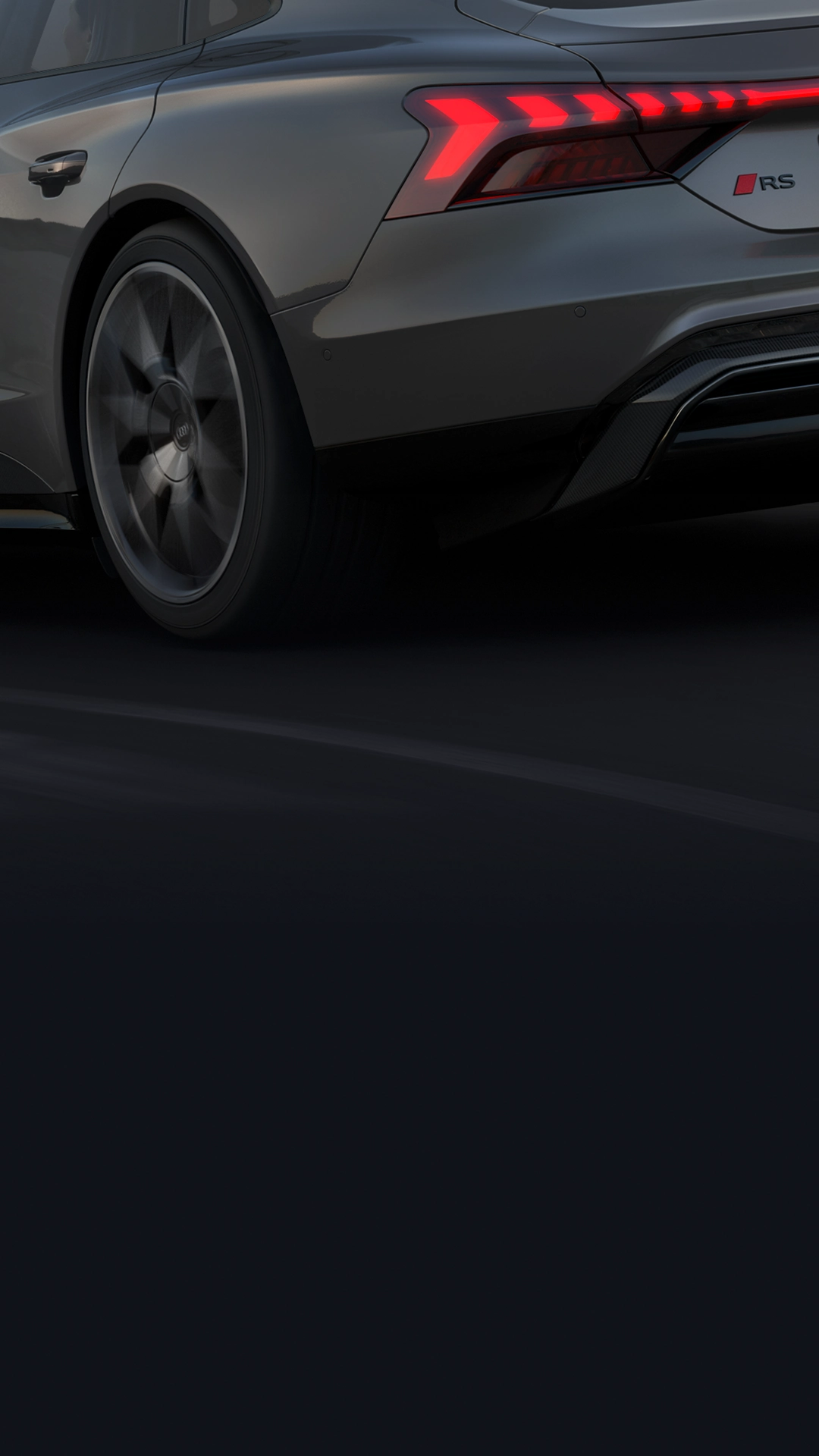 Grey Audi RS e-tron GT car rear quarter, red brake lights on, black wheel and road.