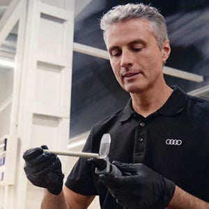 A mechanic pouring oil in a car engine part