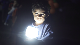 Kind mit Solarlichtquelle im Arm.