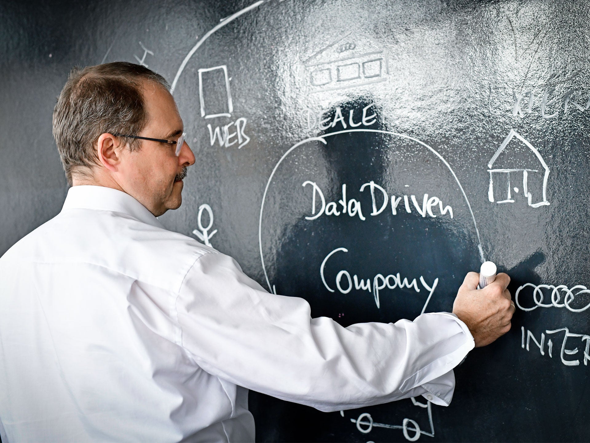 One person drawing on a blackboard with chalk