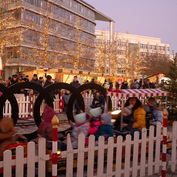 Kids and grown ups on a train on the audi social christmas market.
