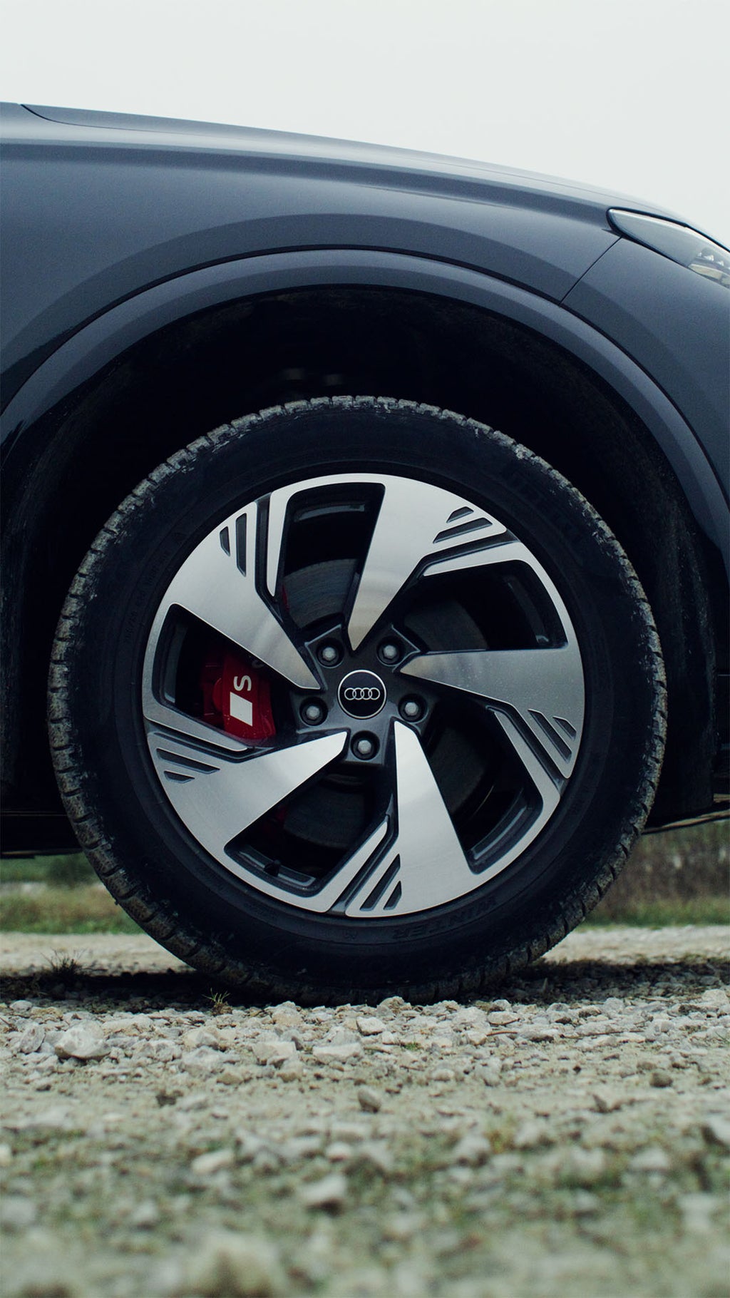 Detail eines Vorderrads des Audi SQ6 e-tron. Man erkennt das S-Logo auf einem rot lackierten Bremssattel.