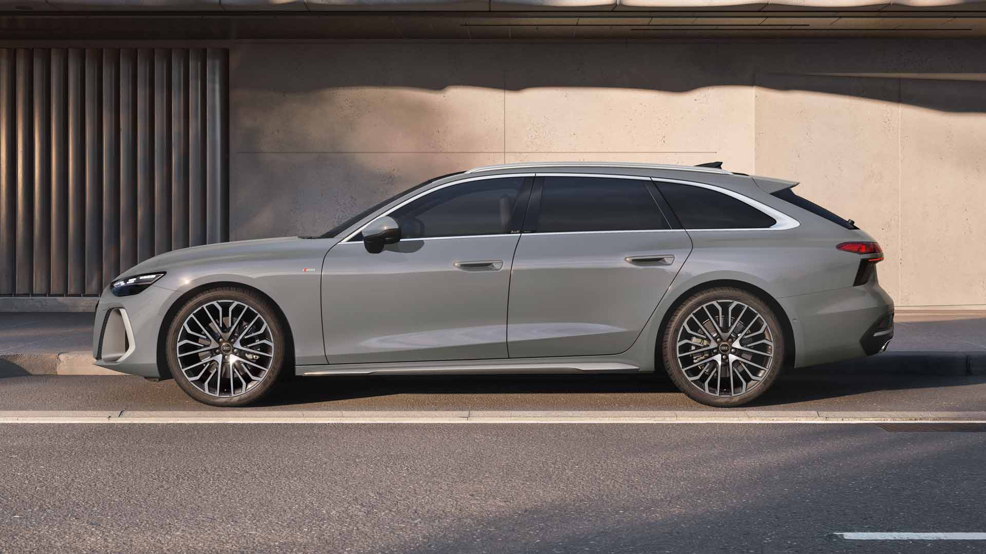 A6 Avant står parkerad på en parkeringsplats framför en byggnadsfasad, sedd från sidan och målad i grått.