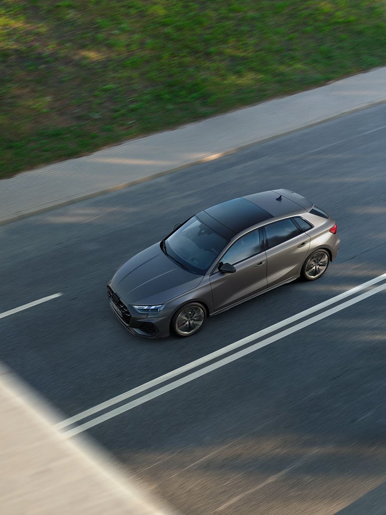 Grauer Audi S3 Sportback aus der Vogelperspektive auf zweispuriger Straße mit weißer Fahrbahnmarkierung.