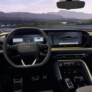 Blick auf das Cockpit des SQ5 Sportback aus der Perspektive des Fahrers. Zu sehen sind unter anderem das Lenkrad mit dem sich dahinter befindlichen Audi Virtual Cockpit, das MMI touch-Display, sowie die Ambiente Beleuchtung.