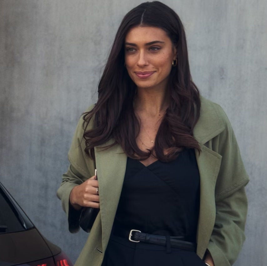 Close up of a woman walking near an Audi car's rear