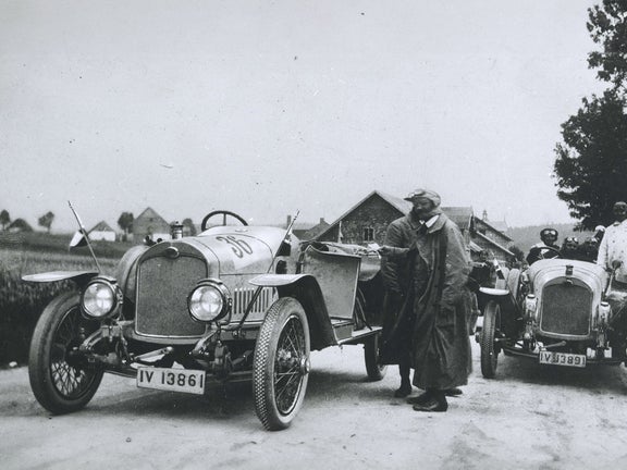 Black and white photograph of people and two Audi Type C Alpine Champion in a rural setting