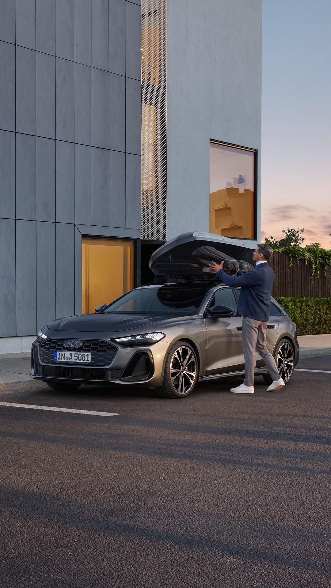 Audi A5のルーフボックスを操作する男性」