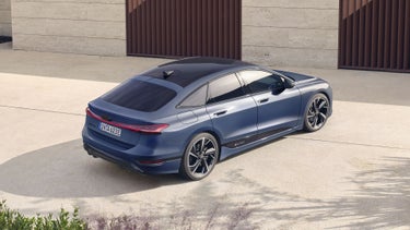 Der A6 Sportback aus schräger, hinterer Vogelperspektive. Er steht auf einem Betonuntergrund vor einer Gebäudefassade.&nbsp;