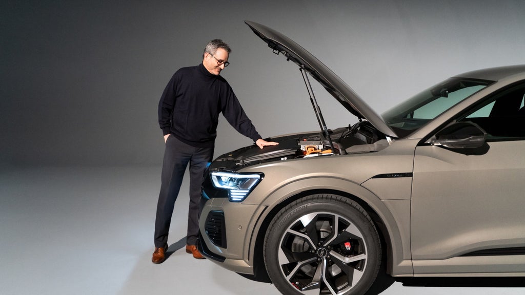 Joachim Doerr zagląda pod otwartą maskę Audi SQ8 e-tron.