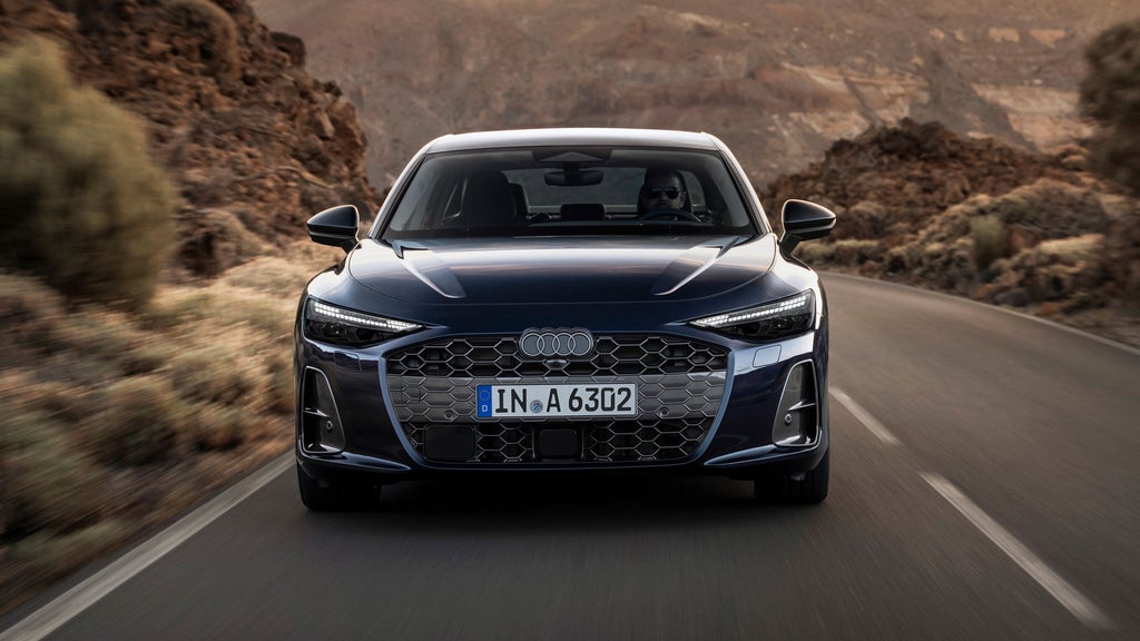 Frontansicht eines Audi A6, der auf einer Wüstenstraße fährt. Gut zu erkennen sind die seitlichen Lusteinlässe und die aerodynamische Gestaltung der Motorhaube.