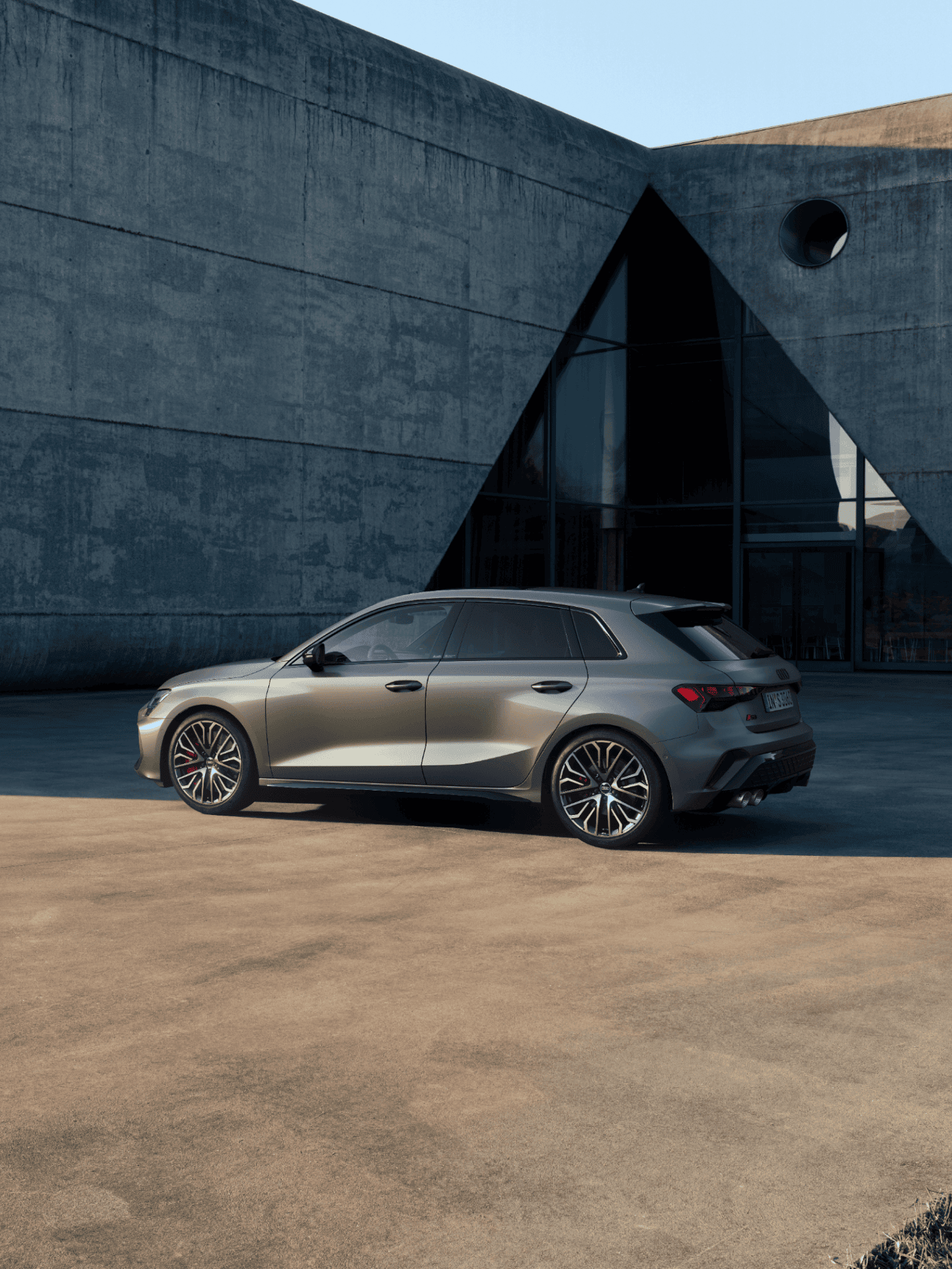 Audi S3 Sportback car parked near a modern building with circular windows.