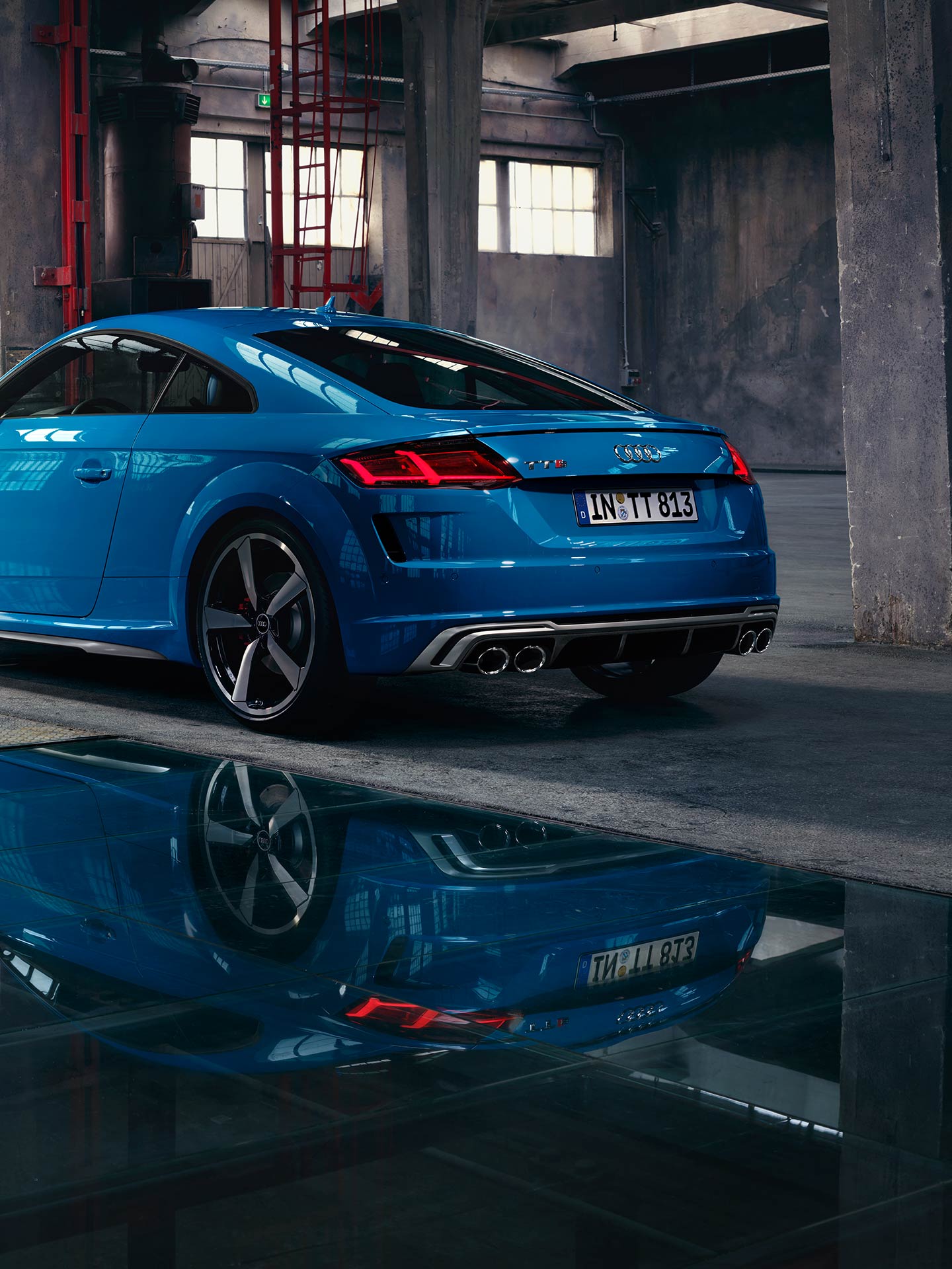 Rear end view of blue Audi TTS Coupe park in garage.