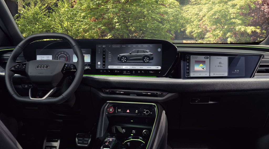 Vue depuis la banquette arrière vers le poste de conduite de l’Audi Q5 SUV. L’accent est mis sur l’écran panoramique avec l’Audi virtual cockpit et l’écran MMI.