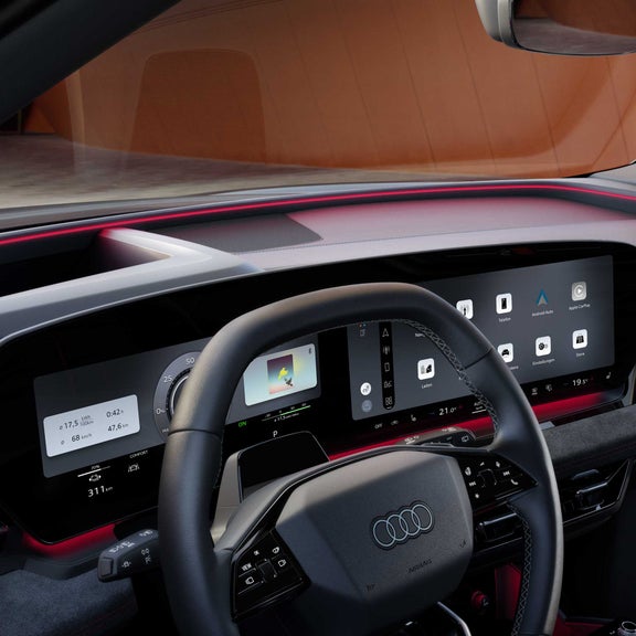 Das Armaturenbrett und die Panorama-Displays aus der Perspektive des Beifahrers. Unter der Windschutzscheibe ist das Interaktionslicht in rot zu erkennen.