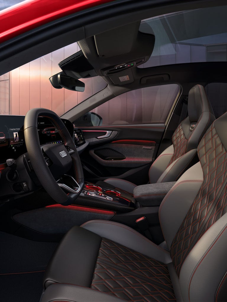 Modernes Interieur einer Audi A5 Limousine mit Sportsitzen, Digitalanzeigen und roten Ziernähten in Schwarz-Grau.