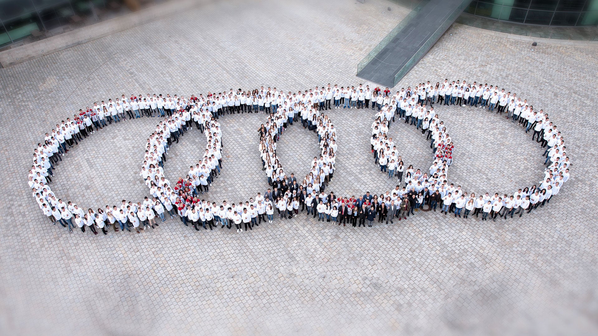Many employees stand in the shape of the four rings and are photographed from above