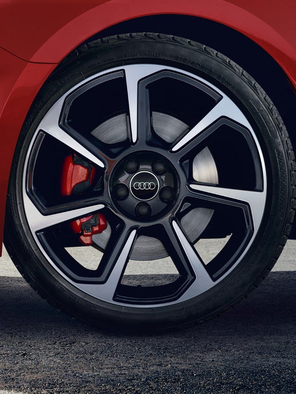 Nahaufnahme einer schwarz-silbernen Audi-Felge mit sichtbarer roter Bremse.