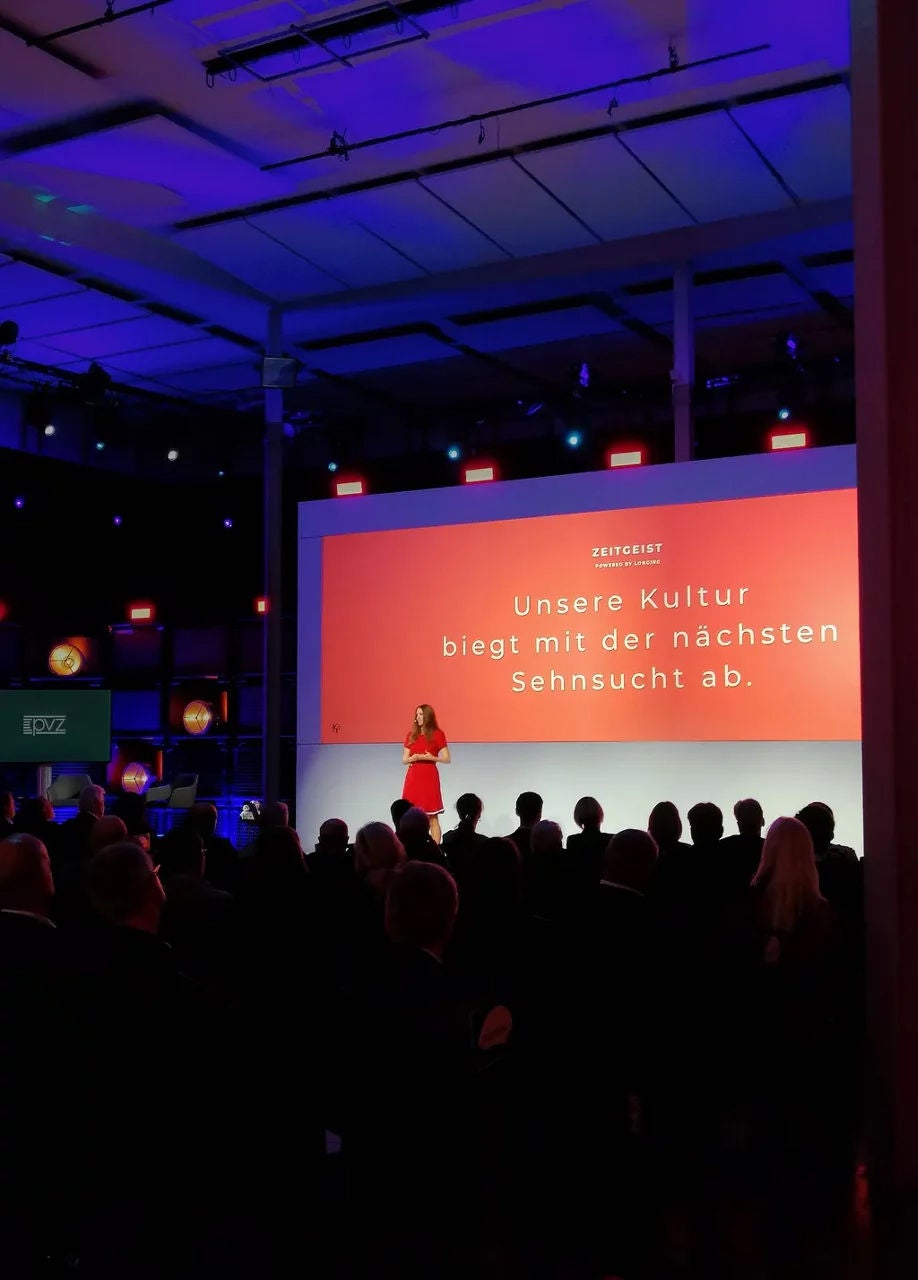 View of the stage from the audience, where Kirstine Fratz is giving a presentation.