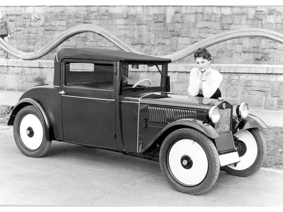 Black and white photo of a woman leaning on a DKW Front F 1