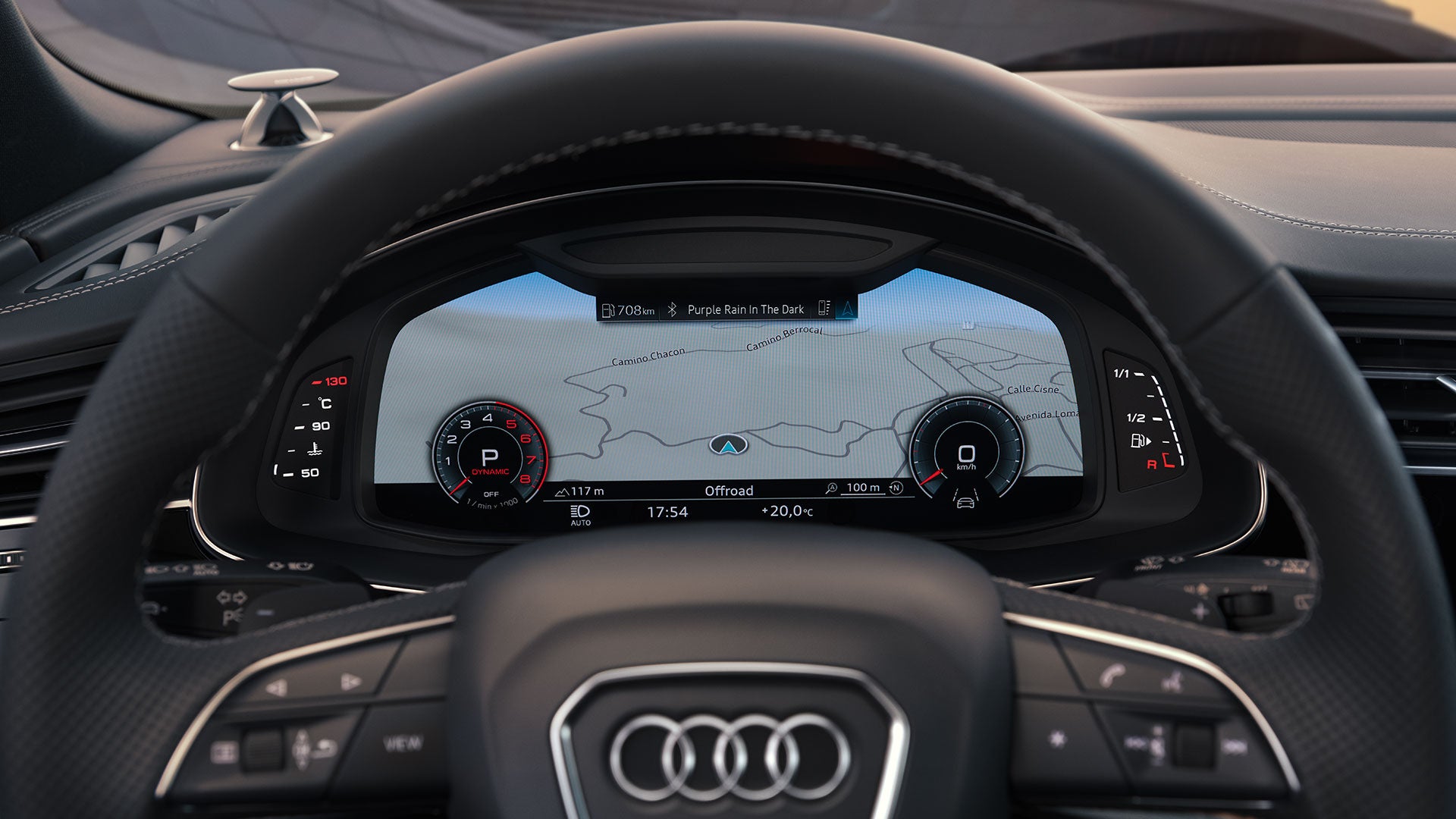Digitales Cockpit eines Audi Q8 SUV zeigt Navigationskarte, Fahrdaten und Songtitel „Purple Rain In The Dark“.