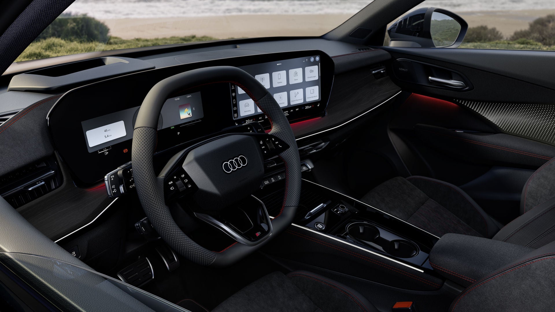 Blick von hinten auf das Cockpit des Q3 Sportback mit Lenkrad, Panoramadisplay und rotem Ambiente-Lichtpaket. Durch die Frontscheibe ist das Meer zu sehen.
