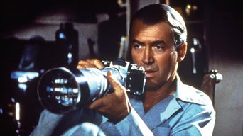 James Stewart sitzt im Rollstuhl am Fenster und hält einen Fotoapparat.