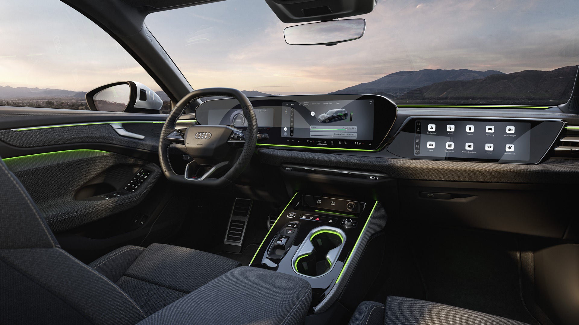 Blick auf die Displays und das Lenkrad im Cockpit des A6 Avant e-hybrid. Durch die Windschutzscheibe sind Berge zu sehen.