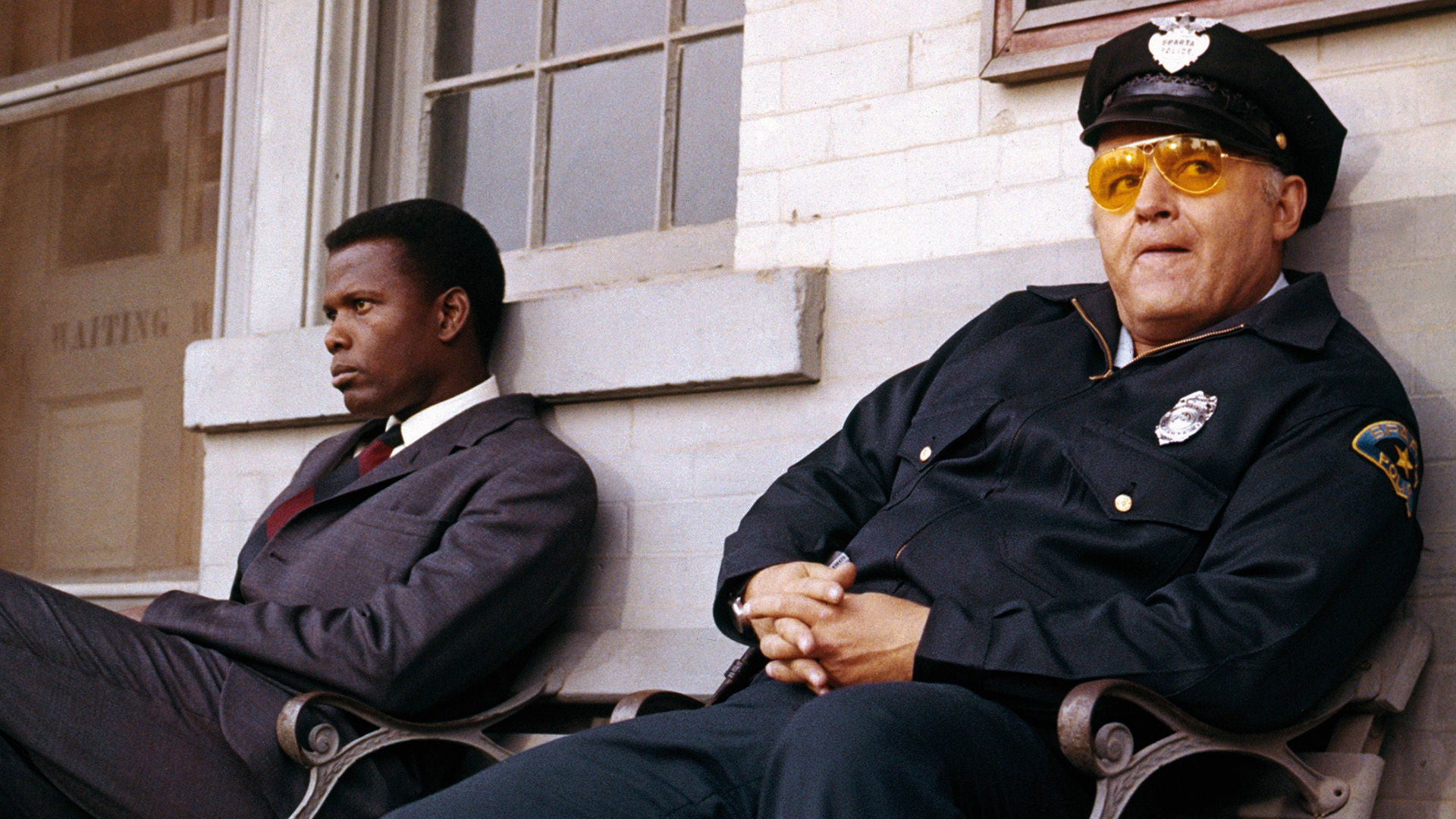 Ermittler Tibbs und Polizist Gillespie sitzen nach rassistischen Auseinandersetzungen auf einer Bank.