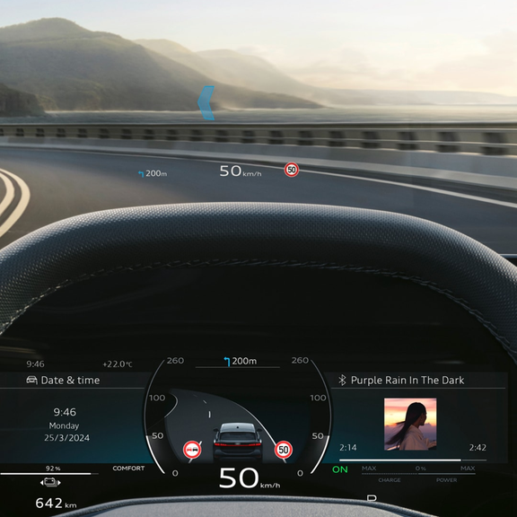 Driver's view inside an Audi vehicle with hands on the steering wheel and digital displays