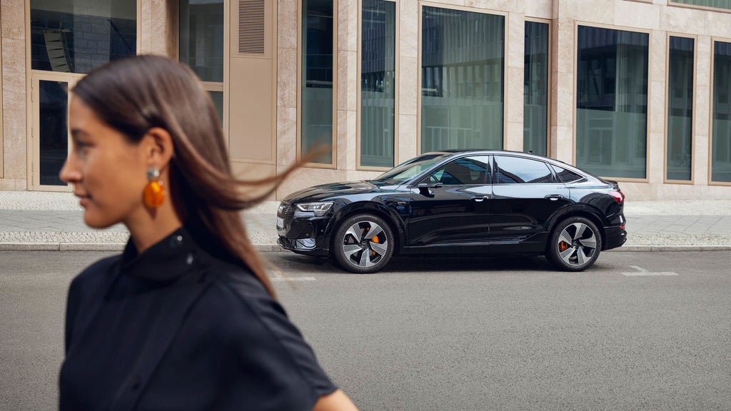 Woman in front of electric vehicle.