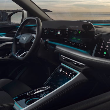 Sleek interior of an Audi car featuring a modern dashboard with digital displays, a stylish steering wheel, and ambient lighting.