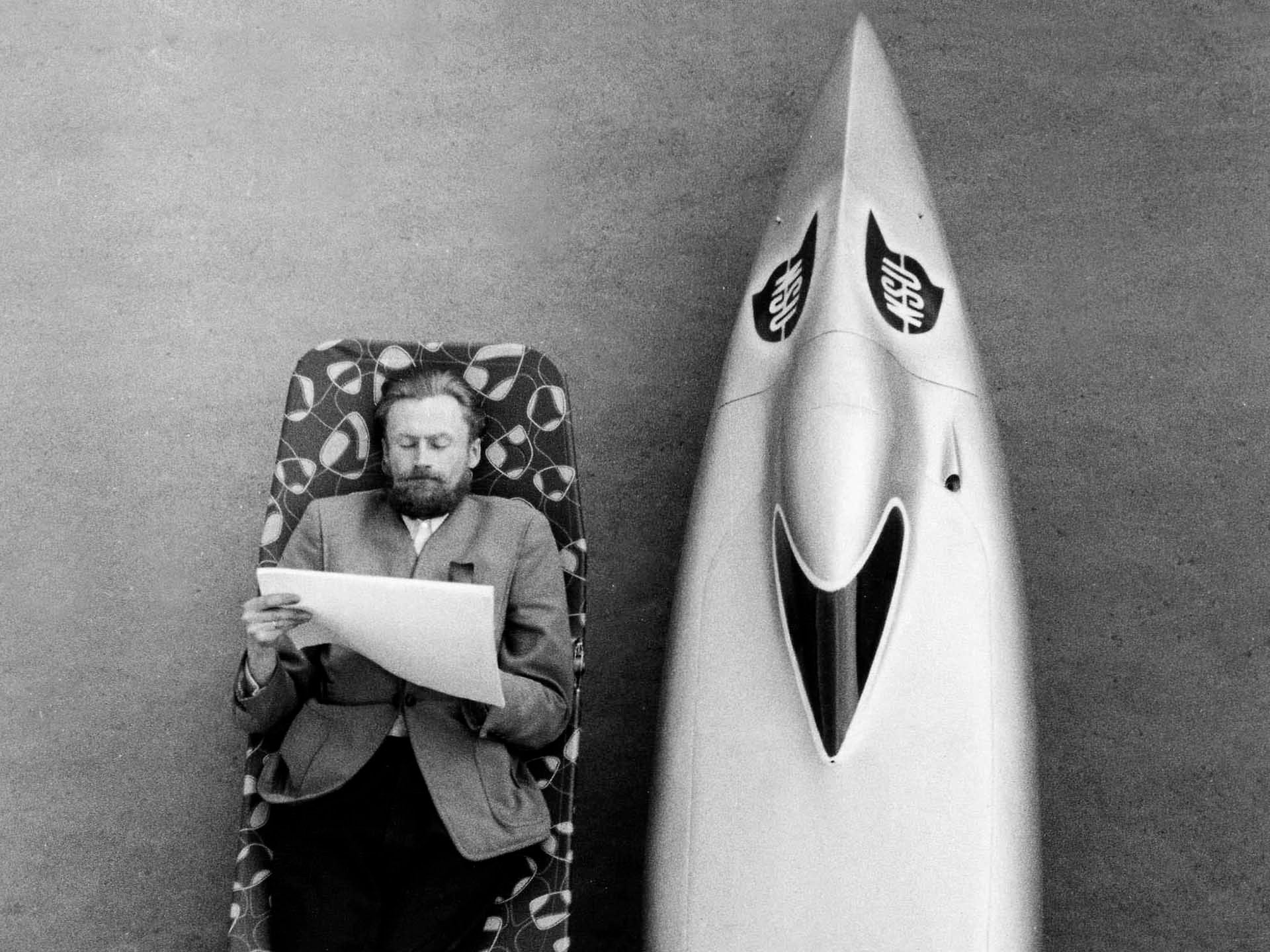 Das Pressefoto zeigt einen Mann, der an einem NSU-Rekordwagen einen Größenvergleich zeigt.
