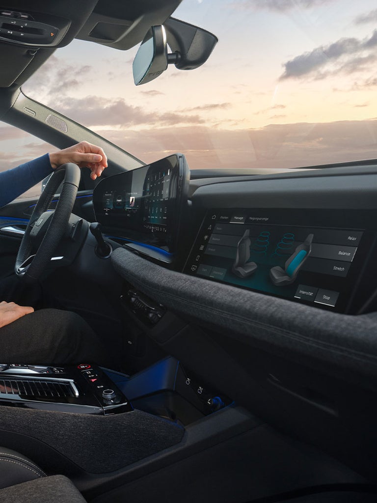 Breites, gebogenes Display mit Navigations- und Medienfunktionen im Cockpit eines Audi Q6 Sportback e-tron.