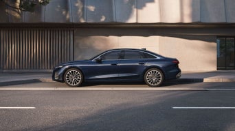 A blue saloon Audi car in motion on the road