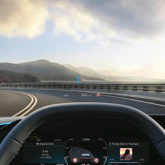 Heads-up display on a car windshield showing speed and navigation with blurred background.